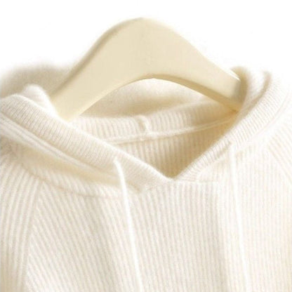 Cream-colored cashmere-mink blend hoodie with ribbed texture and drawstring hood on a hanger.