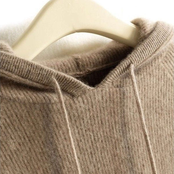 Close-up of a tan cashmere-mink blend hoodie featuring a soft ribbed knit texture and a drawstring hood on a hanger.