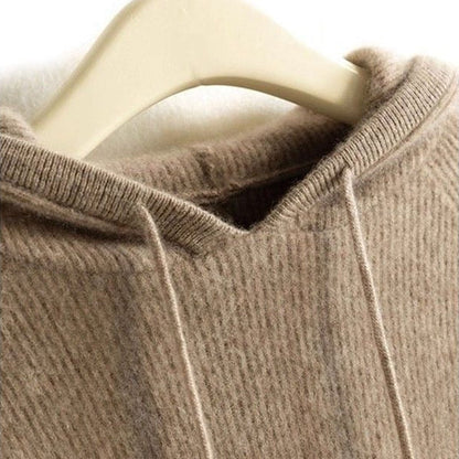 Close-up of a tan cashmere-mink blend hoodie featuring a soft ribbed knit texture and a drawstring hood on a hanger.