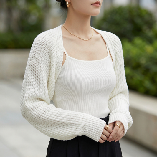 White ribbed knit cropped shrug with raglan sleeves worn over a matching camisole for lightweight layering.